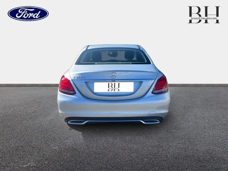 Vue arrière d'une Mercedes Classe C 200 d Business argent iridium avec feux arrière LED et double sortie d'échappement intégrée.