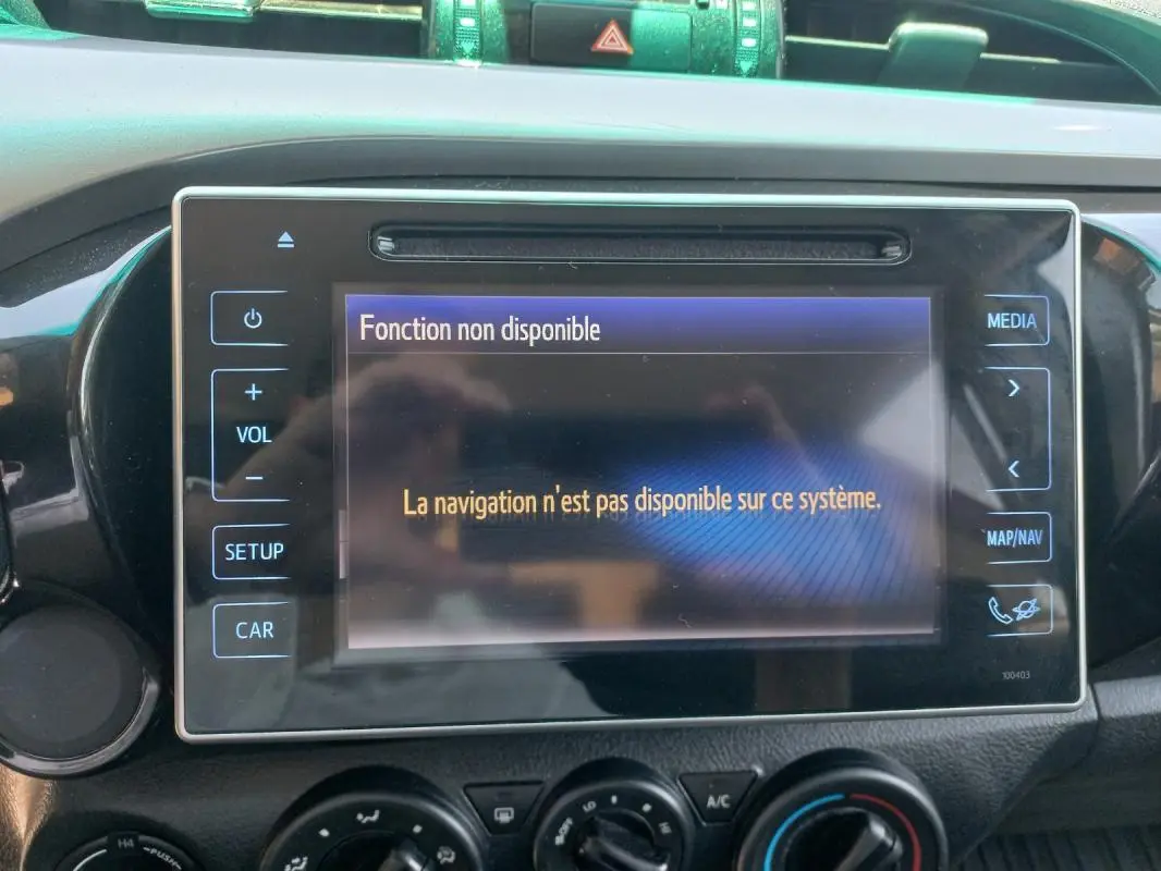 Écran central du Toyota Hilux 2018 affichant un message d'erreur de navigation, entouré des commandes multimédia et climatisation.