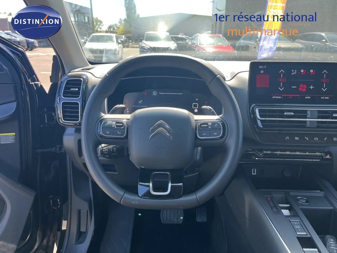 Vue intérieure centrée sur le volant et tableau de bord du Citroën C5 Aircross noir métal, avec écran tactile et commandes intégrées.
