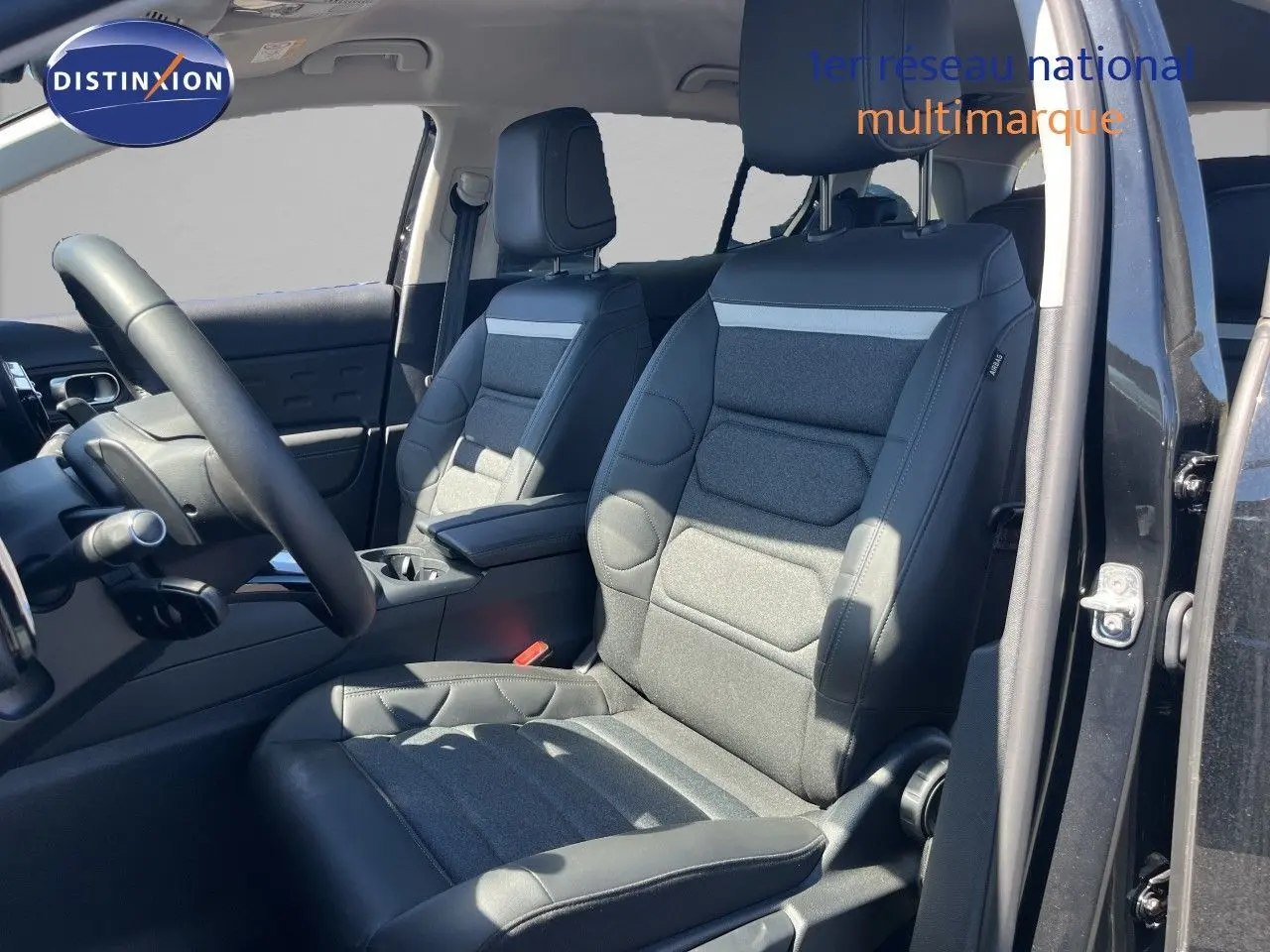 Vue intérieure côté conducteur du Citroën C5 Aircross noir métal, sièges tissu et cuir noir avec détails gris.
