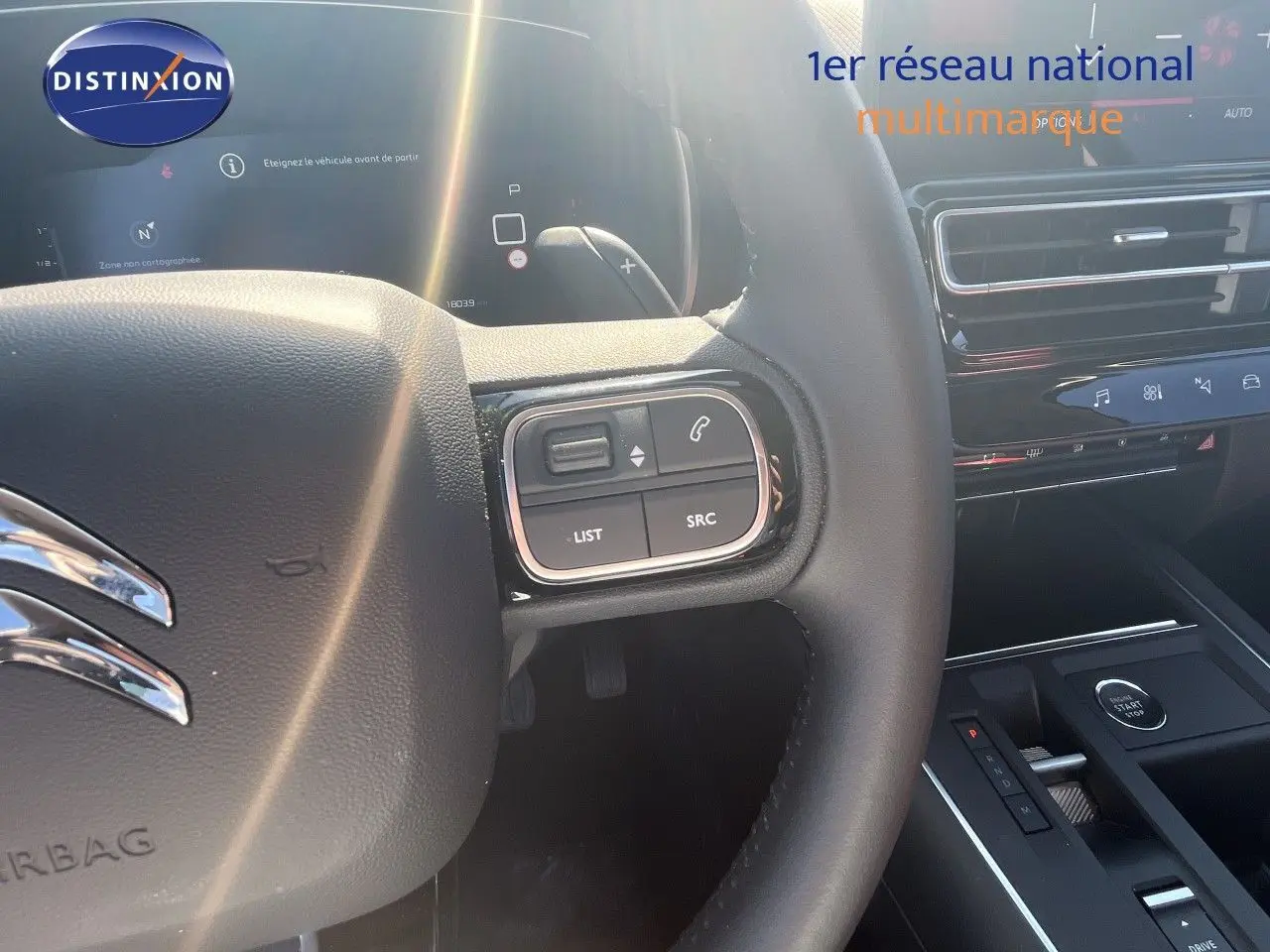 Vue intérieure centrée sur le volant noir du Citroën C5 Aircross 2025 avec commandes intégrées et tableau de bord moderne.