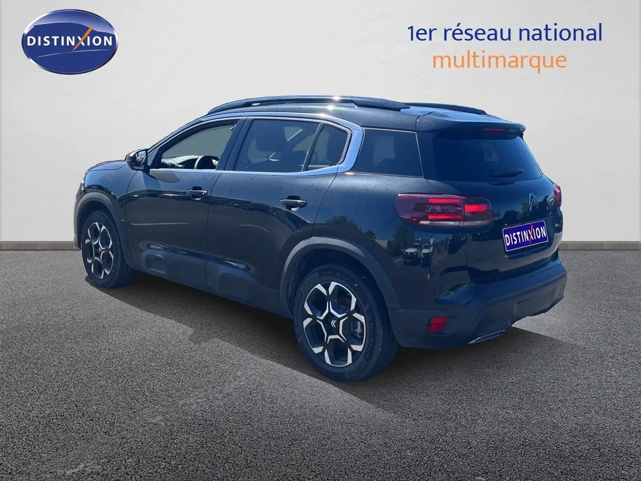 Vue 3/4 arrière droite d'un Citroën C5 Aircross noir métal 2025 avec jantes distinctives et toit noir.