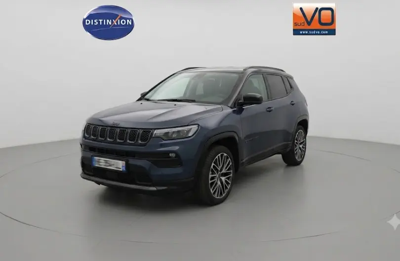 Jeep Compass bleu en 3/4 avant droit, avec jantes alliage 19 pouces et barres de toit visibles.