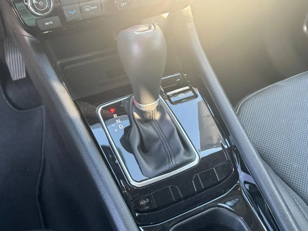 Gros plan sur la console centrale noire du Jeep Compass 2025, mettant en valeur le levier de vitesse automatique et le siège gris.
