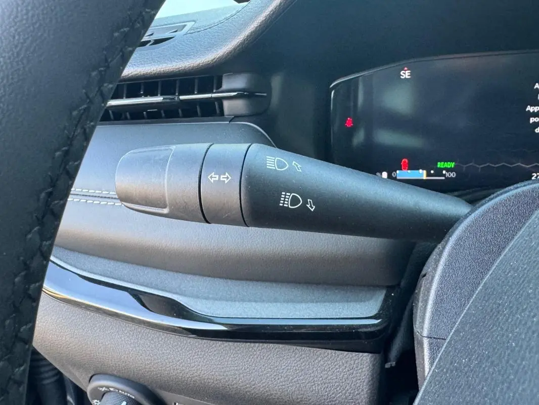 Gros plan sur la commande des phares et clignotants à gauche du volant dans l'habitacle du Jeep Compass 2025.