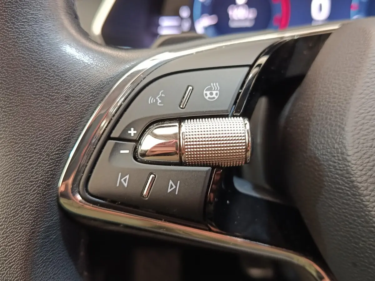 Gros plan sur les commandes en alu et cuir du volant chauffant de la Skoda Octavia 2023, côté gauche.