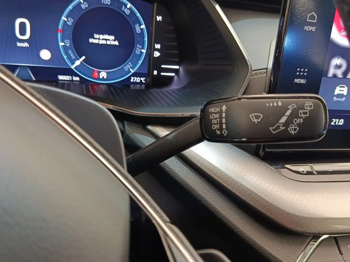 Gros plan sur le combiné d’instruments et la commande d’essuie-glace dans l’habitacle d’une Skoda Octavia blanche 2023.