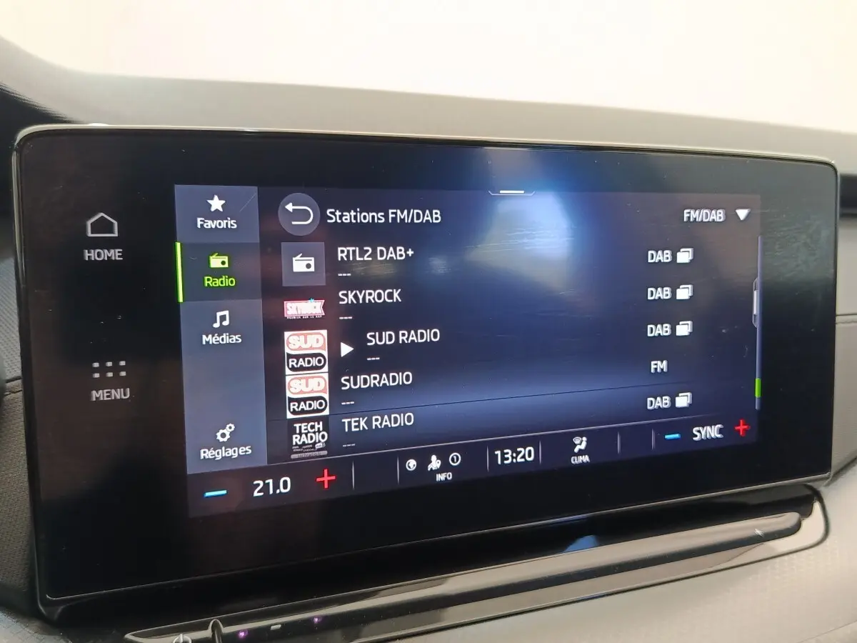 Écran tactile central de la Skoda Octavia 2023 affichant les stations radio FM/DAB, intérieur clair.