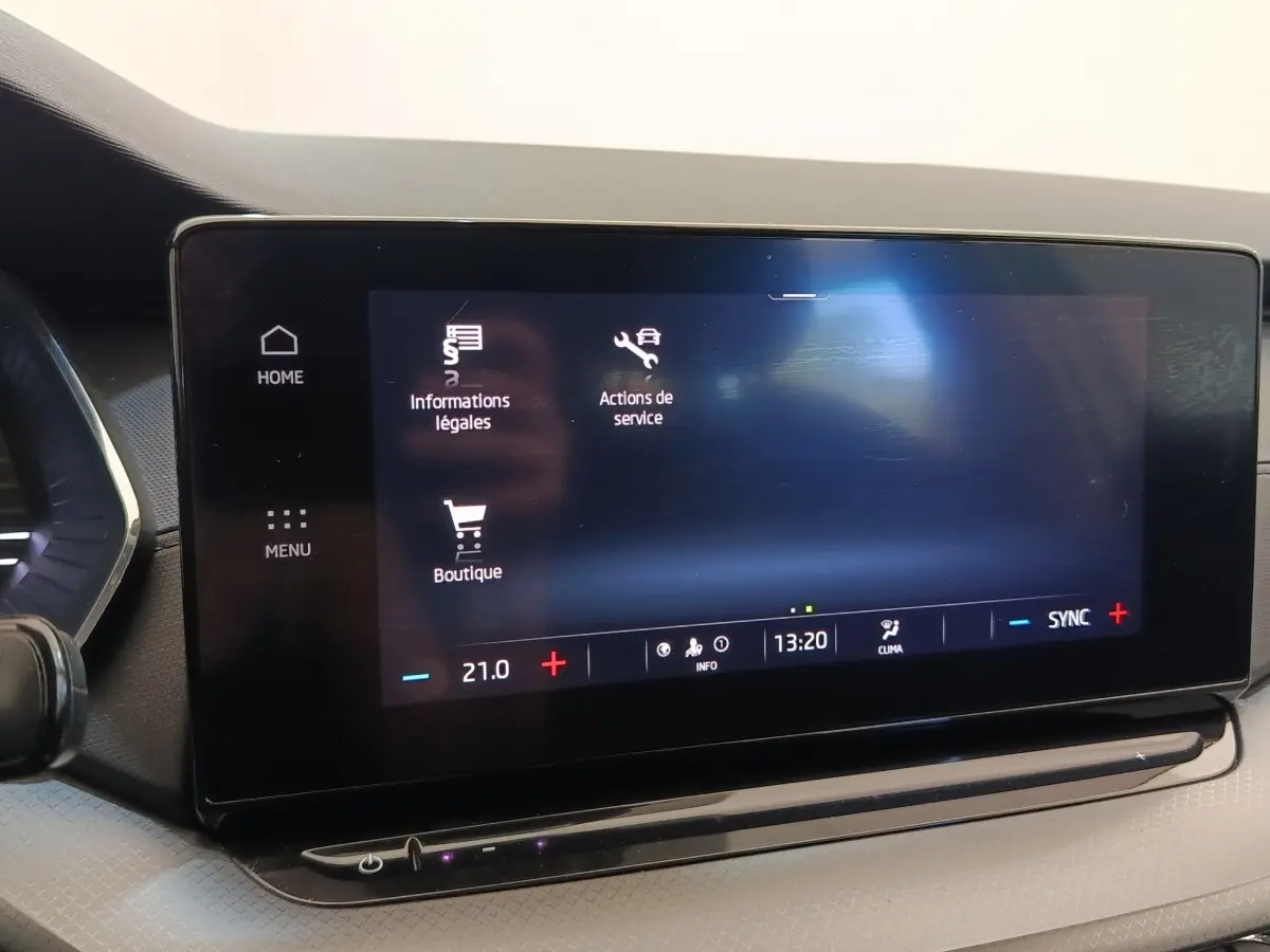 Écran tactile central de la Skoda Octavia 2023 affichant menu et réglages climatisation, intérieur noir.