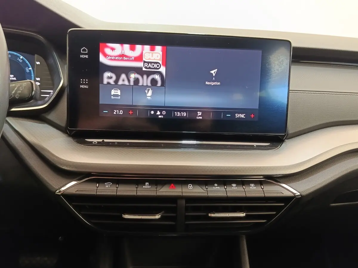 Tableau de bord central de la Skoda Octavia 2023 avec écran tactile large et commandes climatisation visibles.