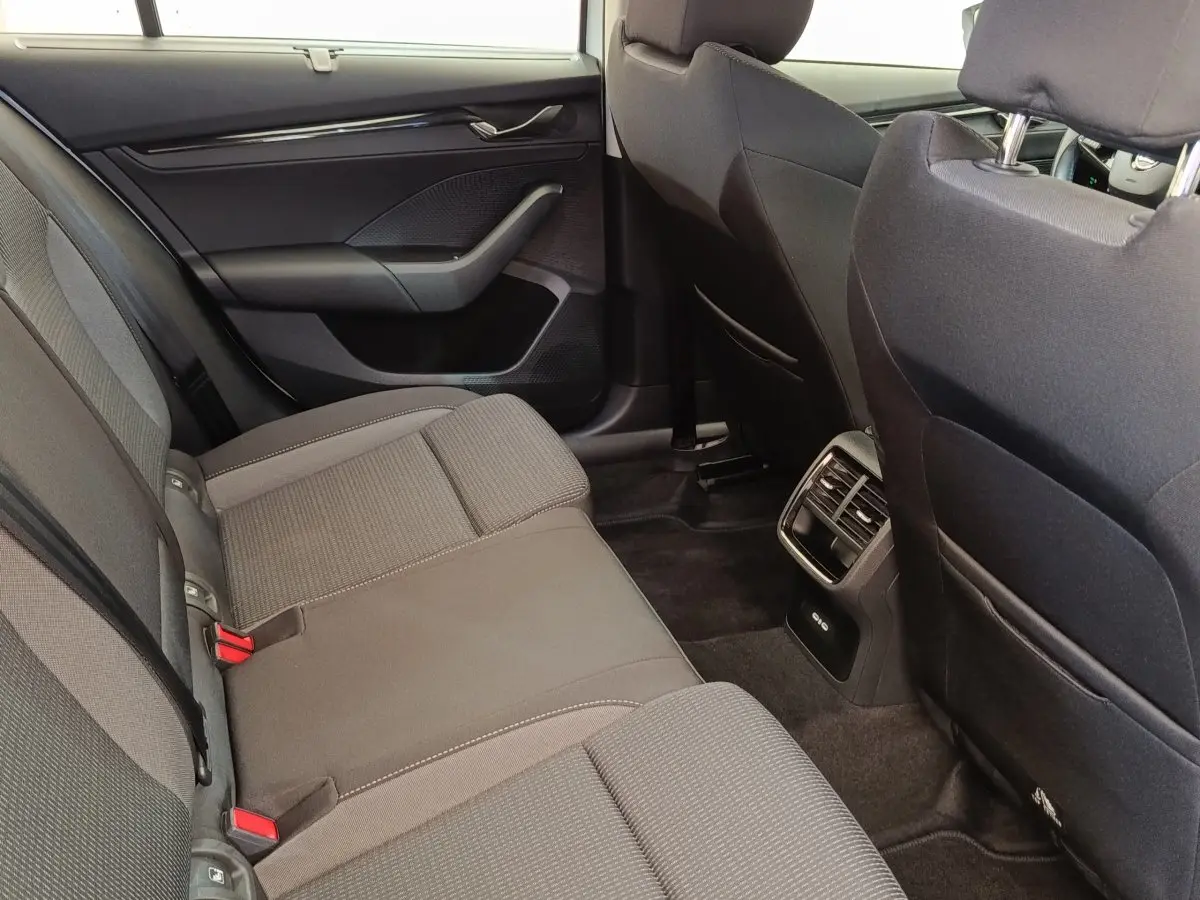 Vue intérieure arrière côté droit de la Skoda Octavia 2023, sièges tissu gris et aérateurs centraux visibles.