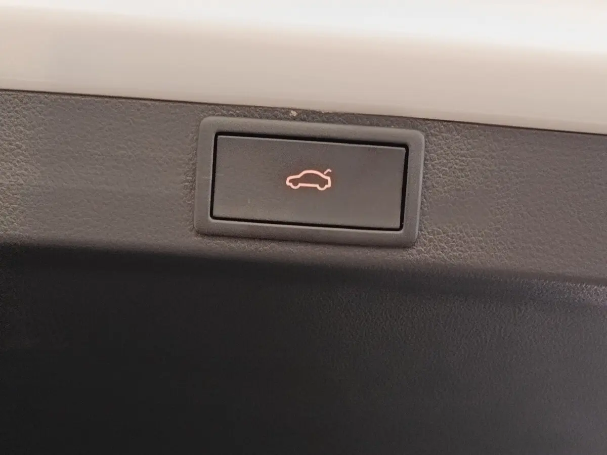 Bouton d'ouverture électrique du coffre sur la partie intérieure d'une Skoda Octavia blanche, version 2023.