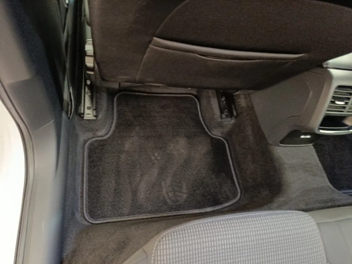 Vue intérieure du plancher arrière côté droit d'une Skoda Octavia blanche avec tapis de sol noir et siège gris.