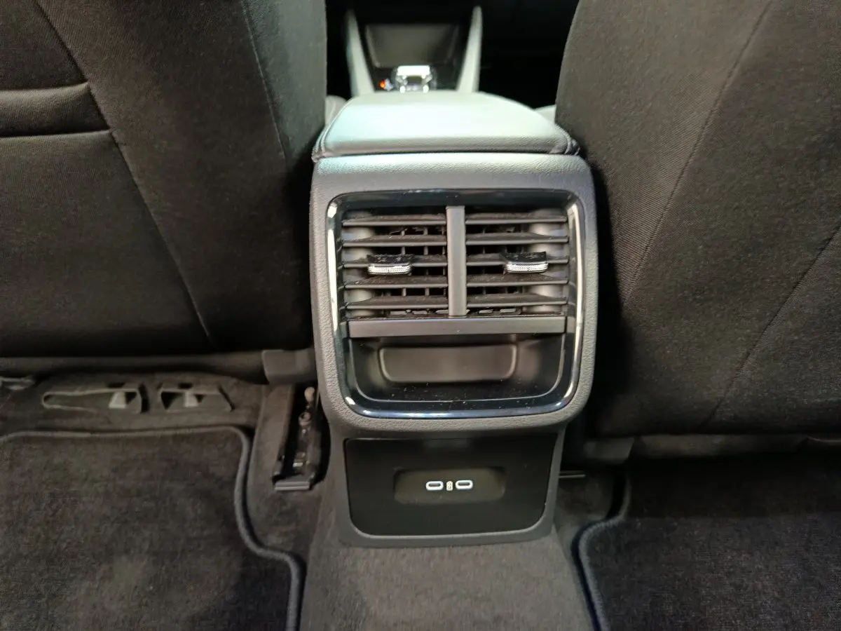 Vue rapprochée des aérateurs arrière et ports USB noirs sur la console centrale entre les sièges arrière d'une Skoda Octavia blanche.