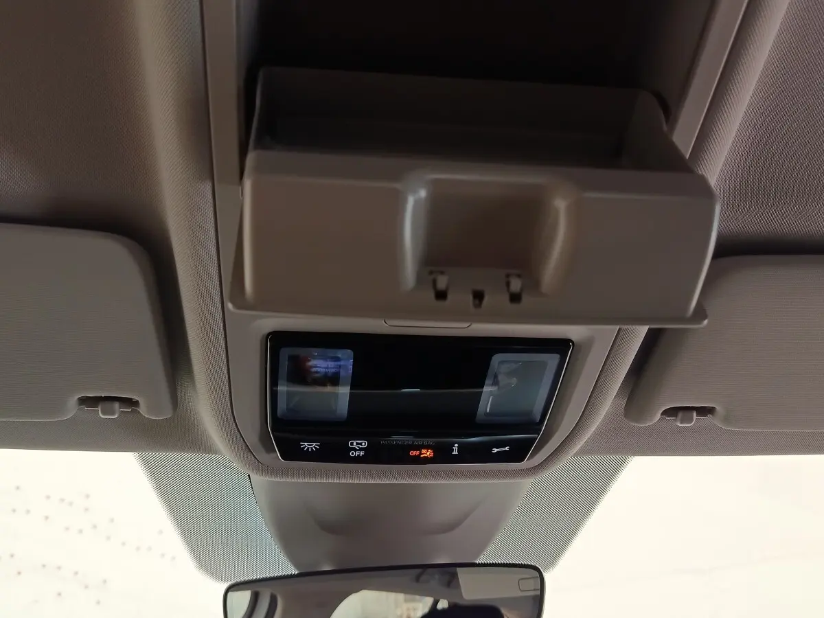 Vue intérieure centrée sur la console de plafonnier avec éclairage et rangement, dans une Skoda Octavia blanche 2023.