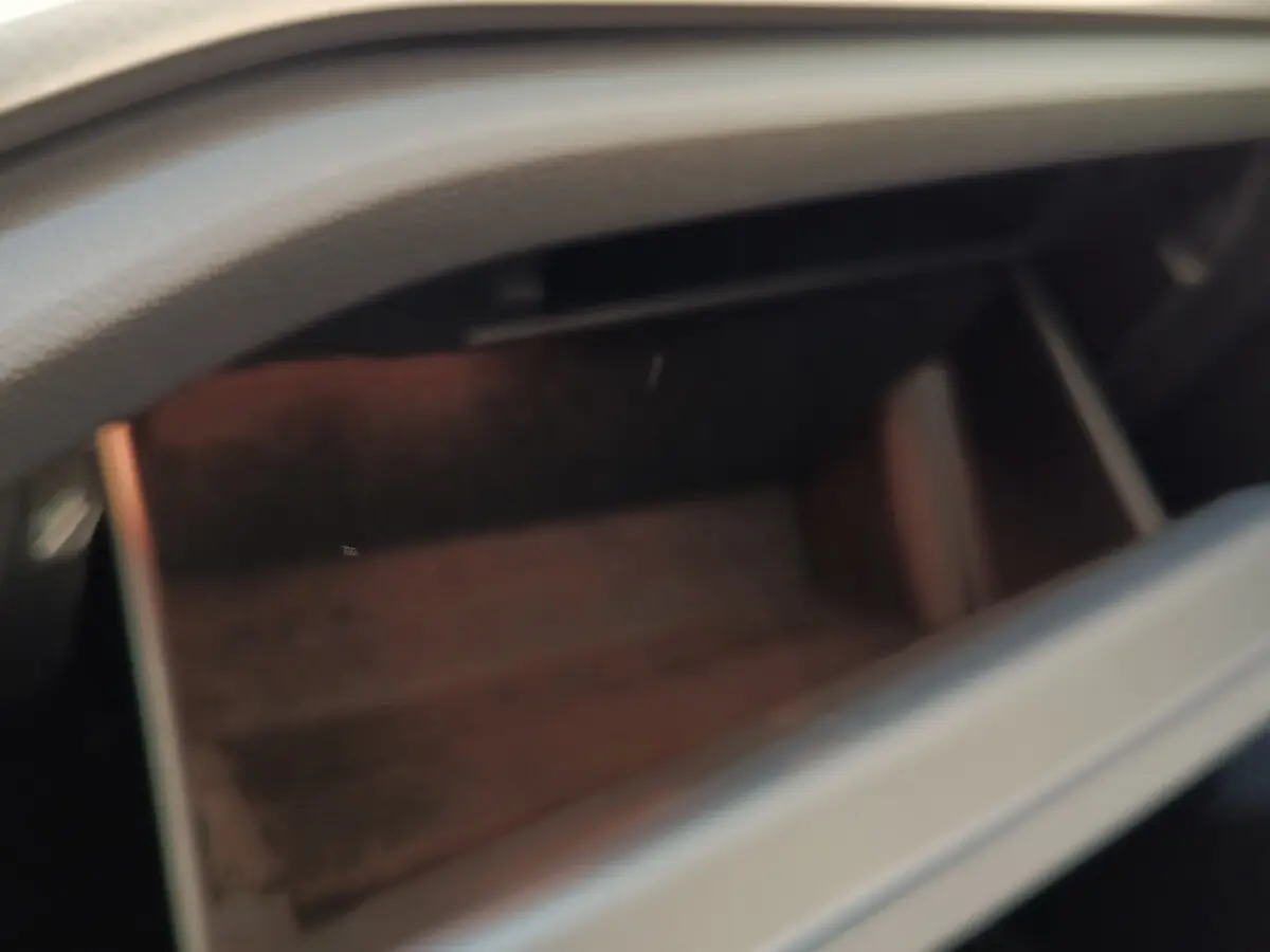 Gant de rangement ouvert dans l'habitacle d'une Skoda Octavia blanche, vue intérieure floue sans autres détails visibles.