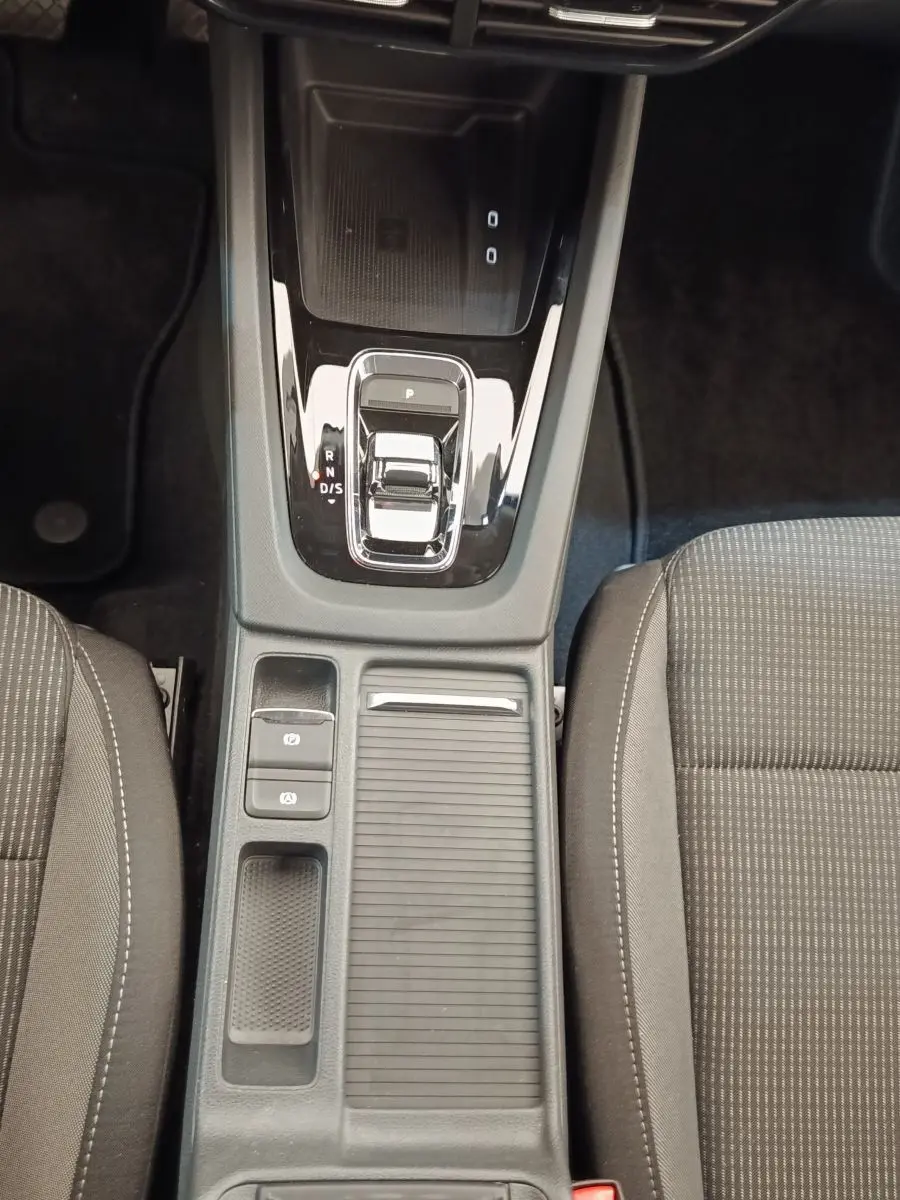 Vue plongeante sur la console centrale noire et la boîte automatique de la Skoda Octavia 2023, sièges gris visibles.
