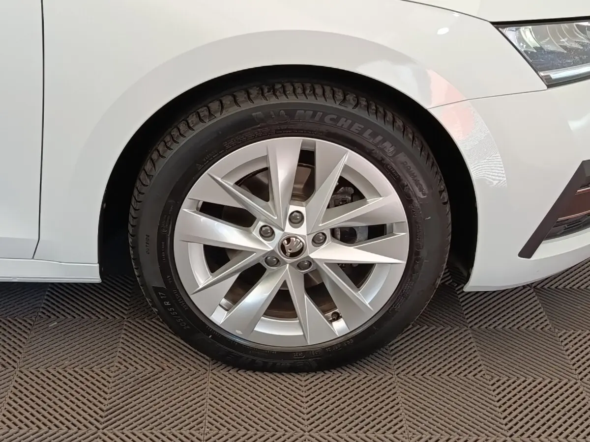 Gros plan sur la roue avant gauche d'une Skoda Octavia blanche 2023 avec jante alliage et pneu Michelin.