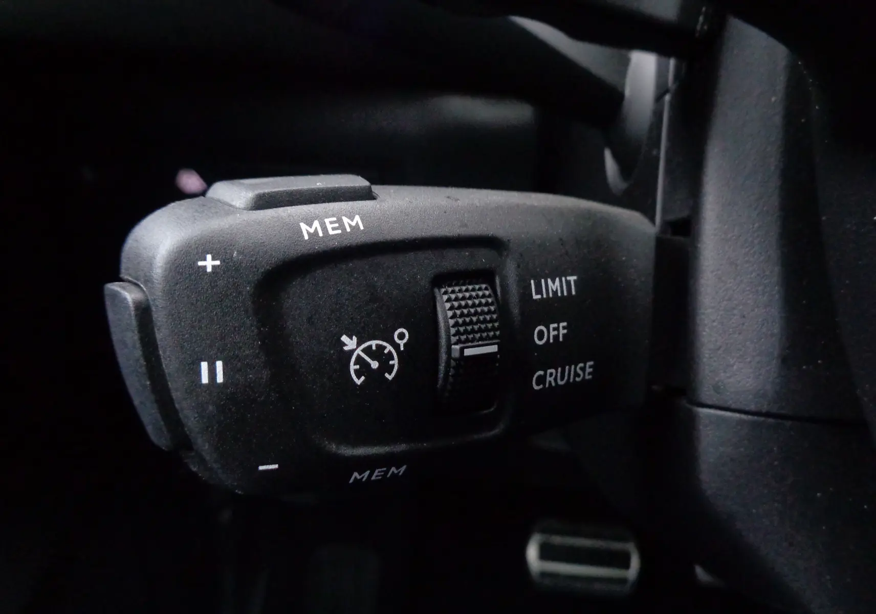 Gros plan sur la commande de régulateur de vitesse du DS3 Crossback blanc banquise, avec boutons MEM et sélecteur LIMIT/OFF/CRUISE.