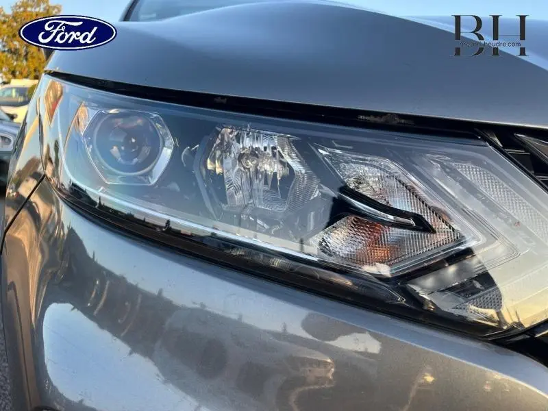 Gros plan sur le phare avant droit du Nissan Qashqai gris Squale 2019, mettant en valeur ses détails lumineux.