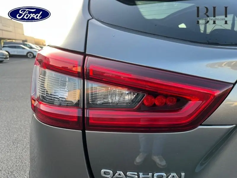 Gros plan sur le feu arrière droit rouge et blanc d'un Nissan Qashqai gris Squale 2019, avec logo visible.