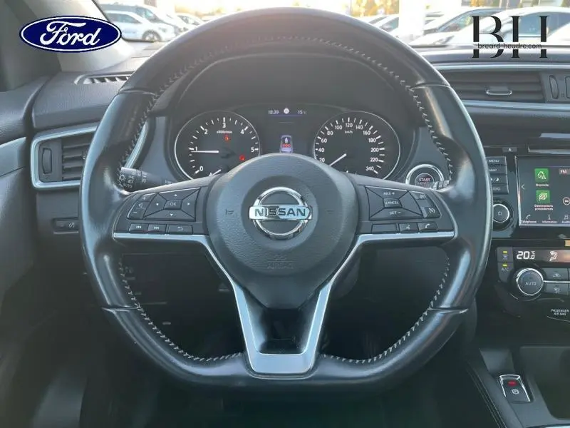 Vue rapprochée du volant cuir noir d'un Nissan Qashqai 2019 avec tableau de bord et commandes visibles.