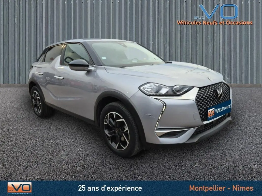 Vue 3/4 avant gauche d'un DS3 Crossback gris métallisé avec jantes alliage noires et calandre distinctive en losange.