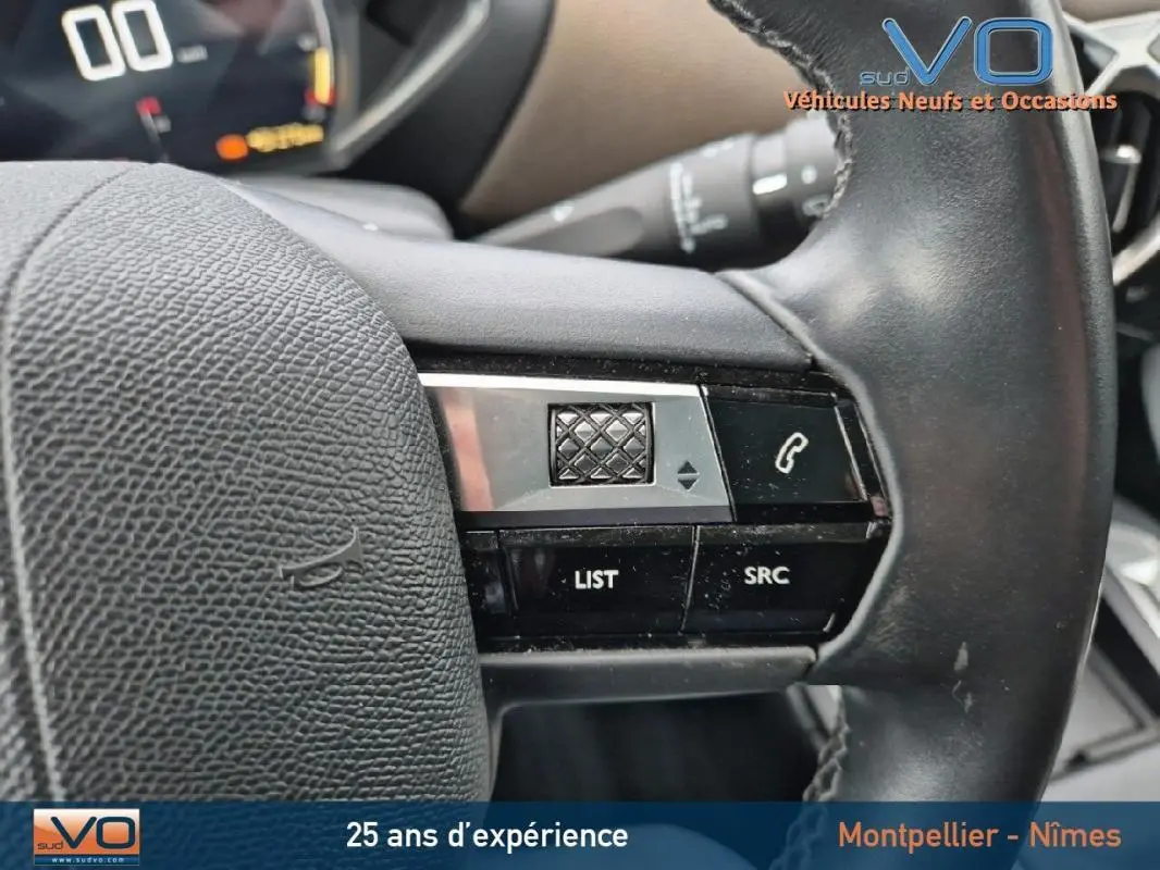 Gros plan sur les commandes au volant noir du DS3 Crossback gris, mettant en valeur les boutons de contrôle audio et téléphone.