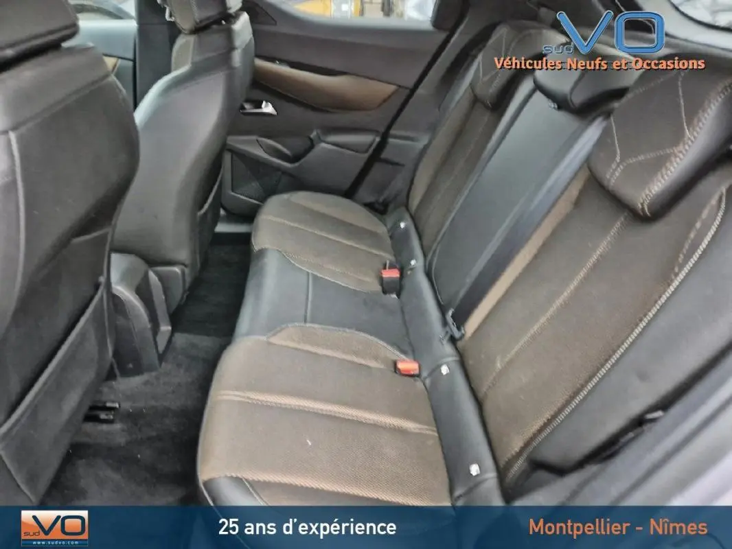 Vue intérieure montrant la banquette arrière en tissu marron et cuir noir du DS3 Crossback gris de 2020.