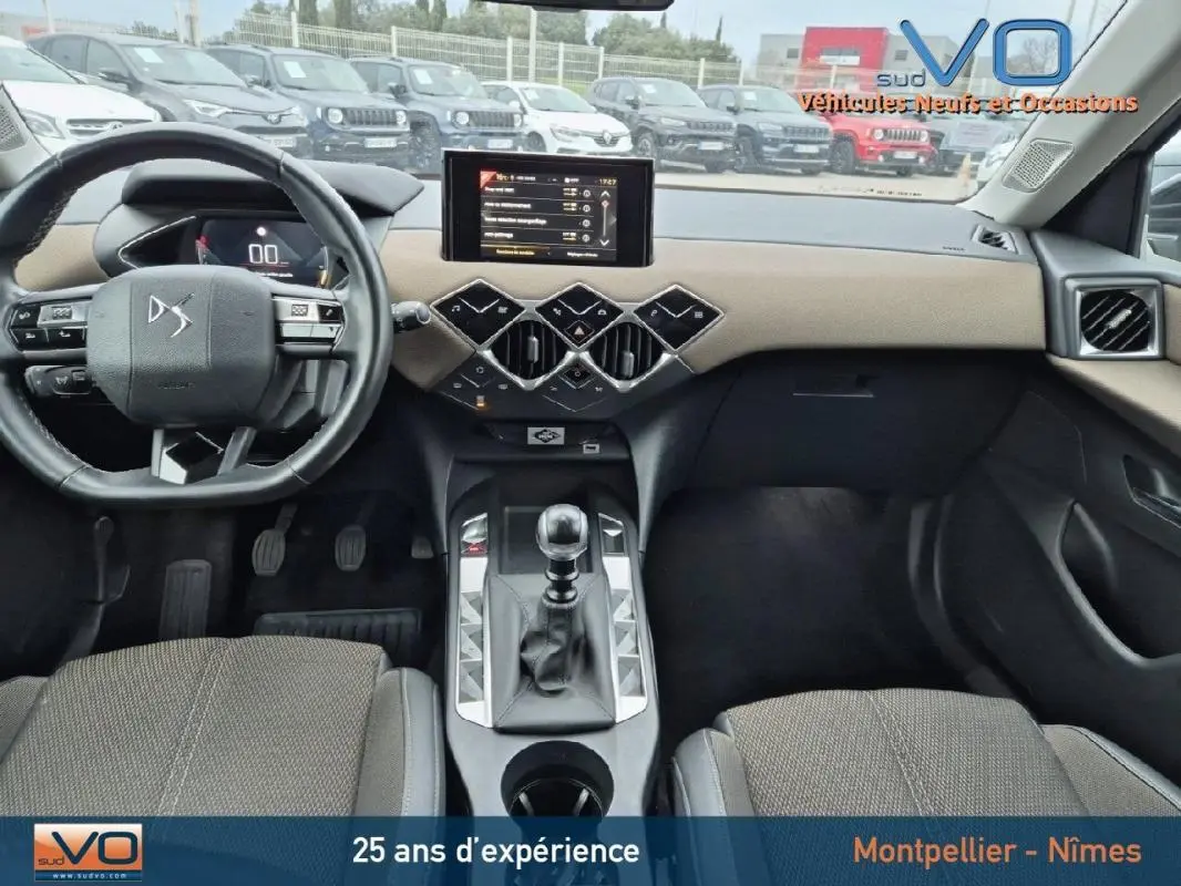 Vue intérieure avant du DS3 Crossback gris 2020, volant multifonctions, écran tactile et levier de vitesse manuel visibles.