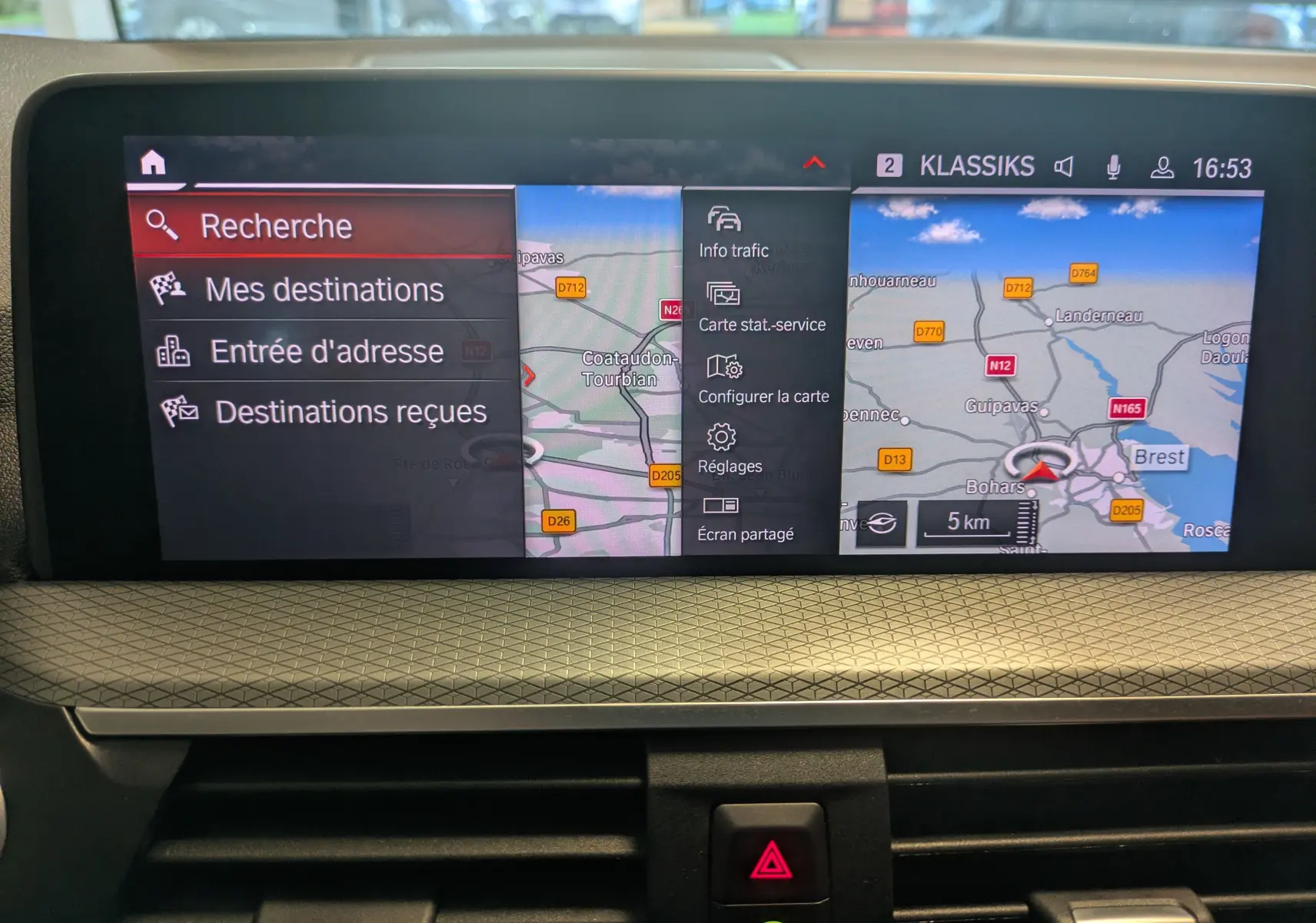 Écran central du tableau de bord du BMW X4 blanc 2021 affichant le menu navigation et carte GPS.