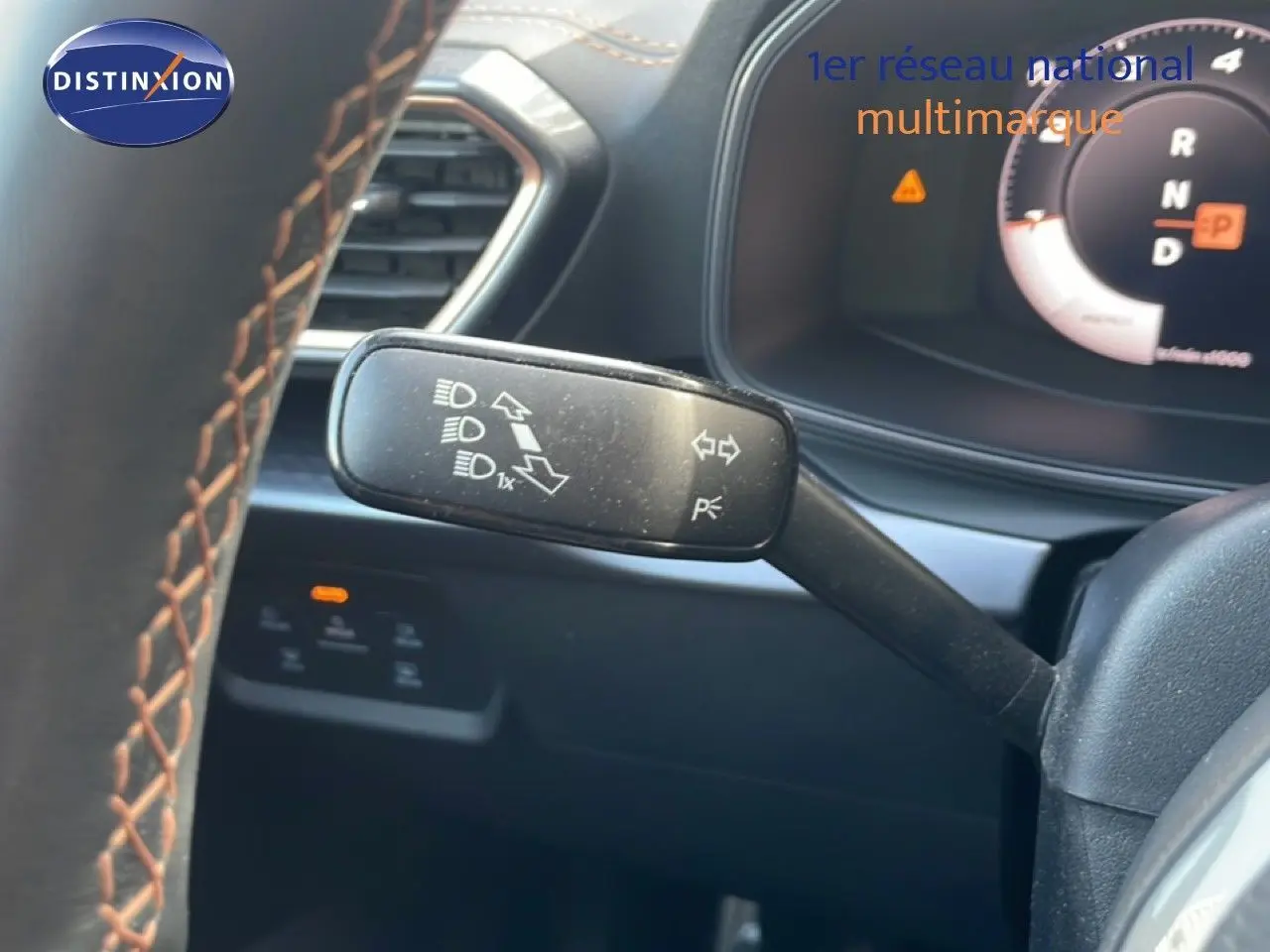 Gros plan sur la manette de clignotant à gauche du volant d’un CUPRA Formentor blanc neige métal, tableau de bord partiellement visible.