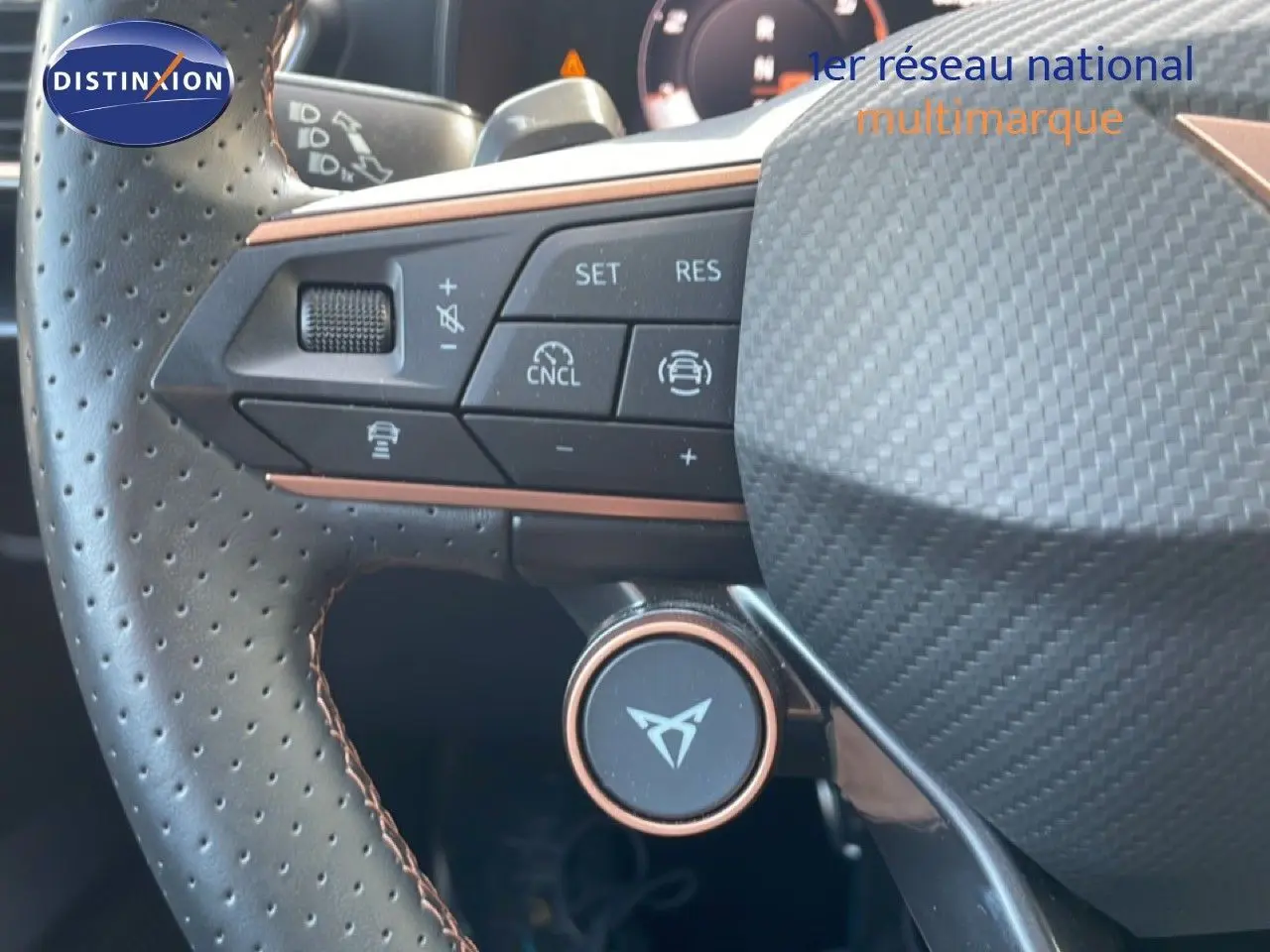Gros plan sur le volant perforé noir avec surpiqûres marron du CUPRA Formentor 2.0 TDI 150CH DSG 2025, boutons de commande visibles.
