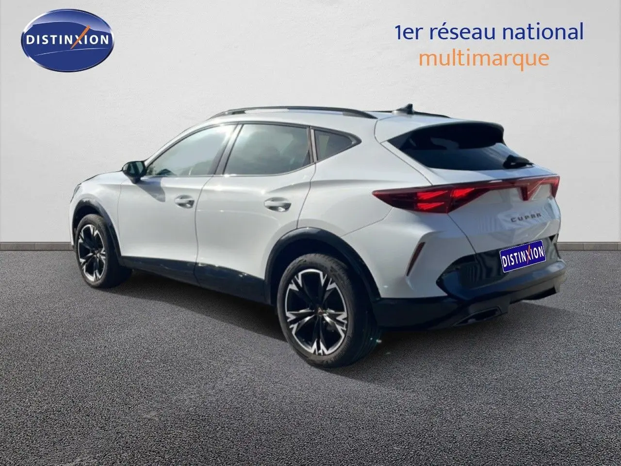 Vue 3/4 arrière droite d’un CUPRA Formentor blanc neige métal avec jantes noires et toit panoramique.