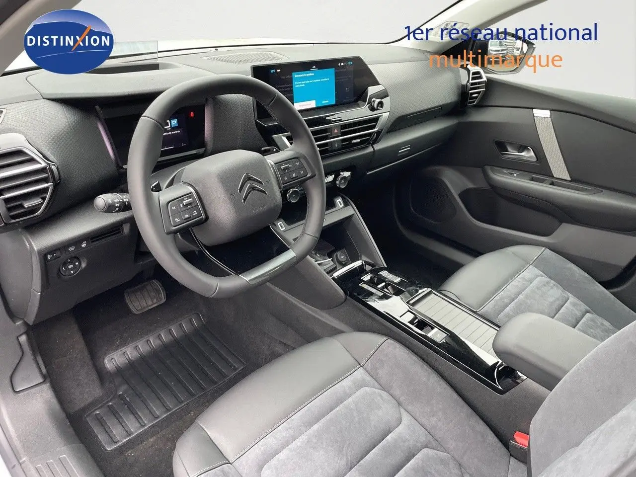 Intérieur noir et gris de la Citroën C4 2024, vue côté conducteur avec tableau de bord digital et volant multifonction.
