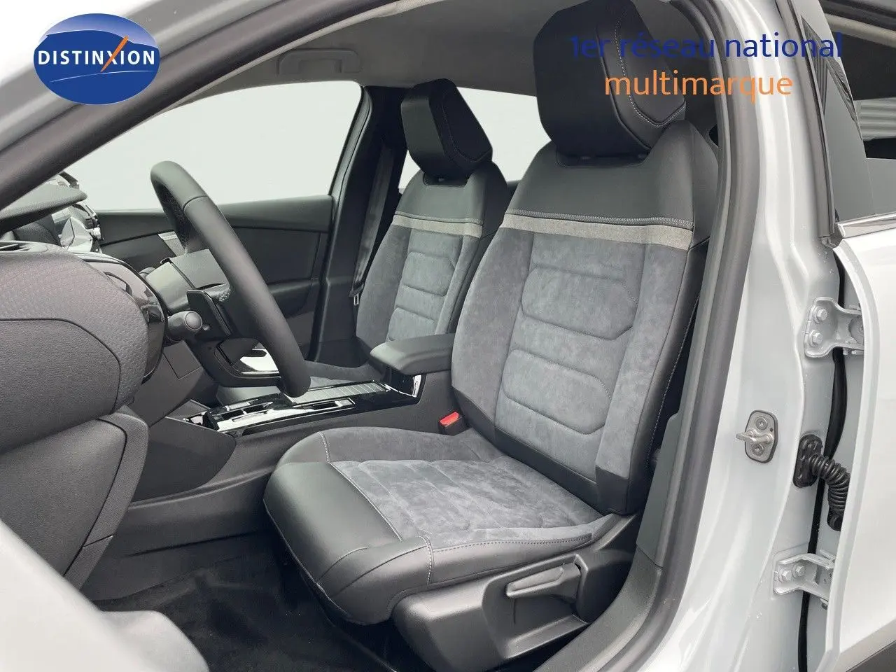 Intérieur côté conducteur d'une Citroën C4 blanche 2024, sièges en cuir et alcantara gris avec console centrale moderne.