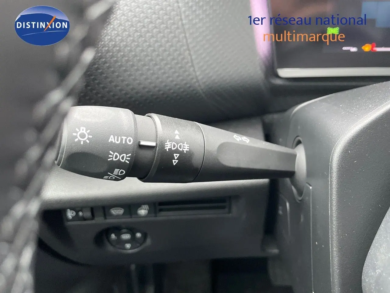 Gros plan sur la commande des phares et clignotants à gauche du volant dans une Citroën C4 blanche métal 2024.