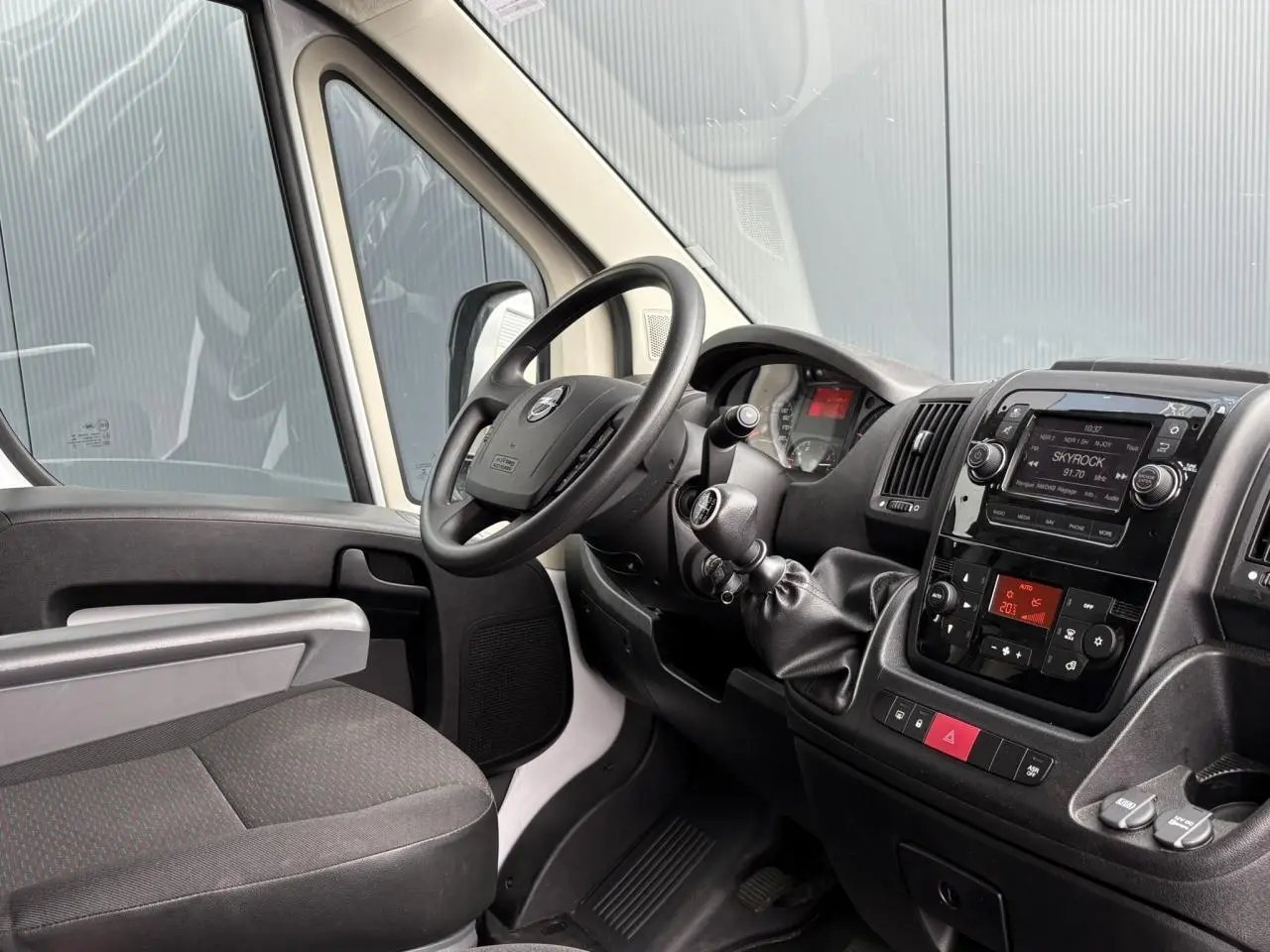 Vue intérieure côté conducteur de l'Opel Movano Fourgon blanc 2023, avec tableau de bord et volant visibles.