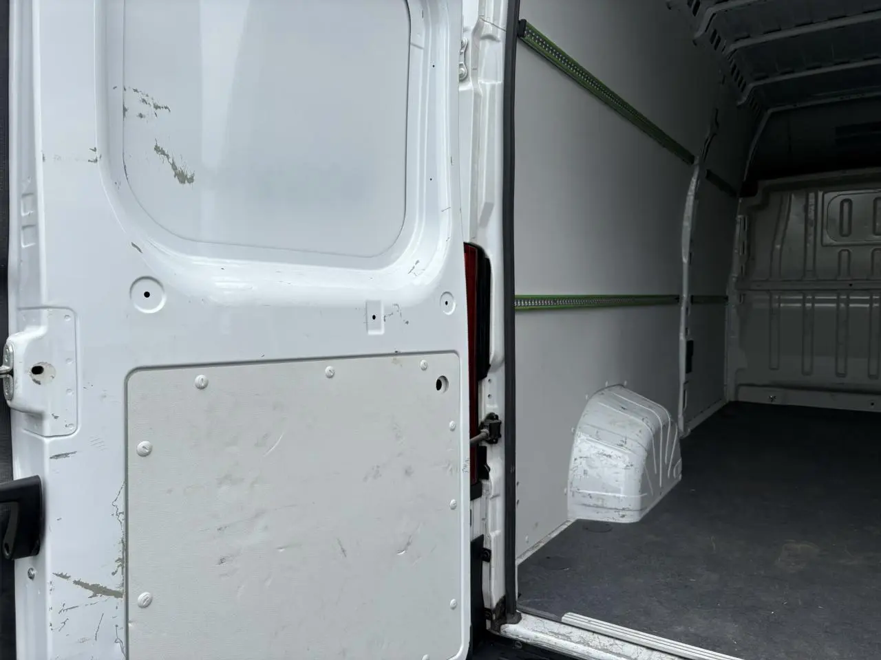 Vue intérieure arrière du fourgon blanc Opel Movano L4H3 2023 avec plancher et habillage latéraux visibles.
