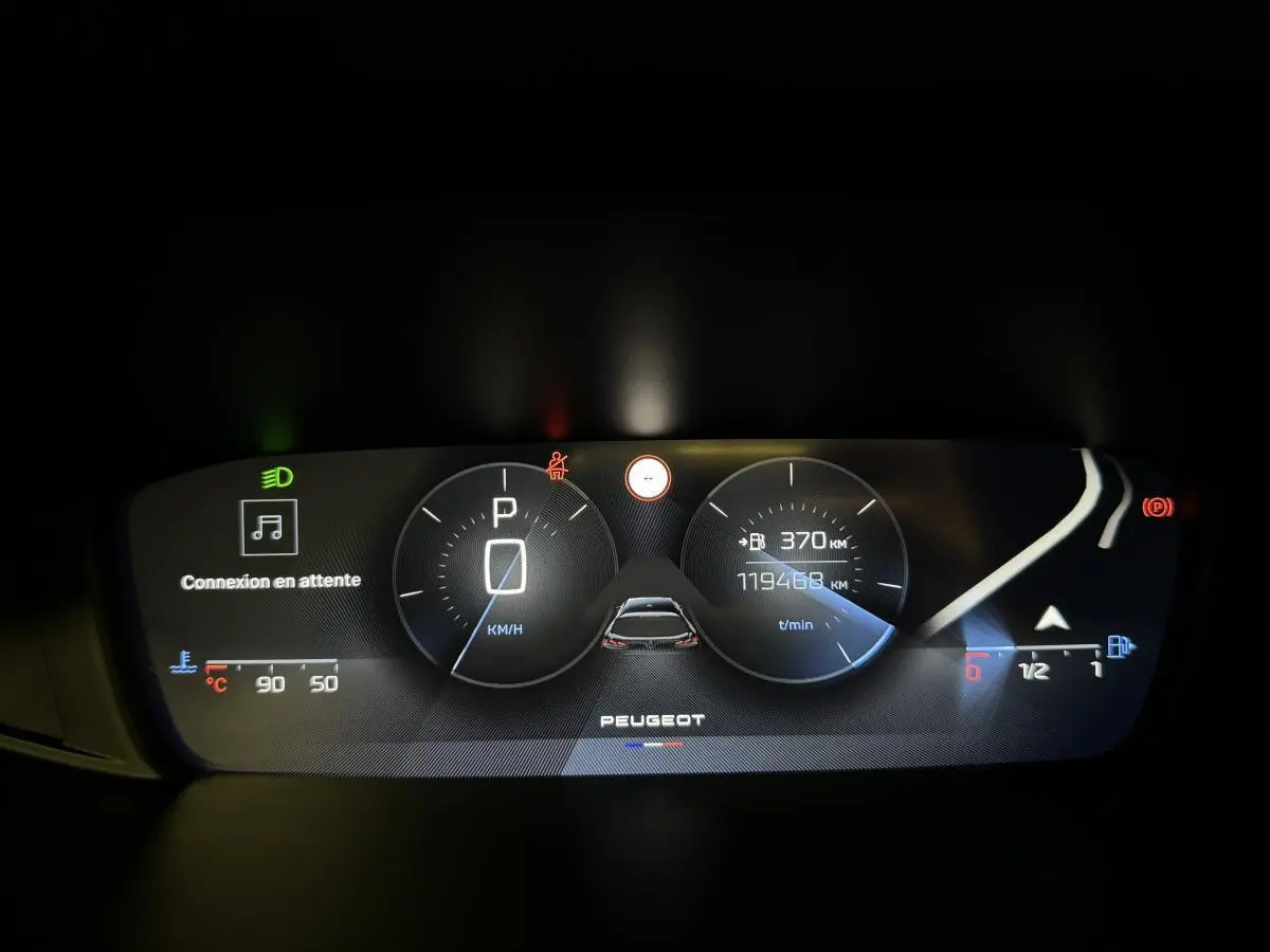 Combiné numérique du tableau de bord de Peugeot 308 SW 2022 affichant la vitesse à l'arrêt et l'autonomie restante.
