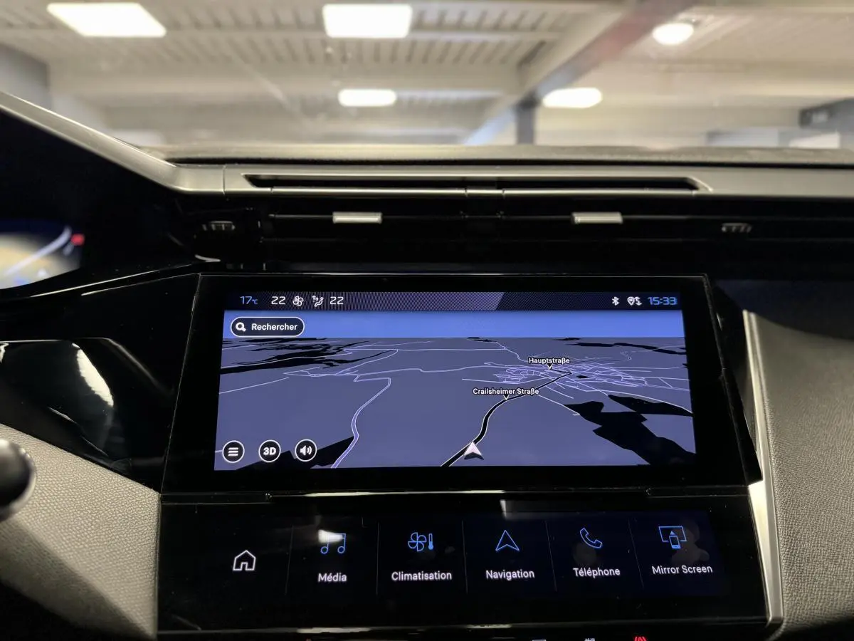 Écran tactile central de navigation allumé dans l'habitacle d'une Peugeot 308 SW gris, vue de face rapprochée.
