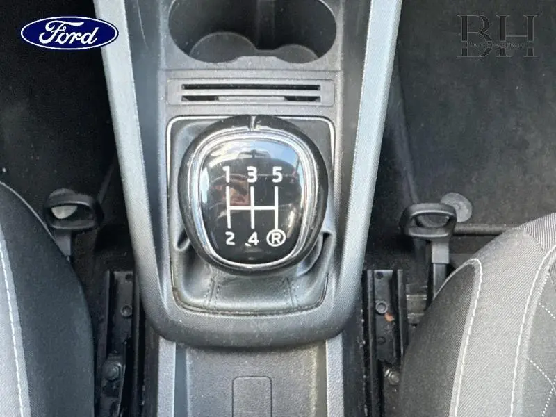 Gros plan sur le levier de vitesses manuel noir entouré de plastique gris dans l'habitacle d'une Skoda Fabia gris météore.