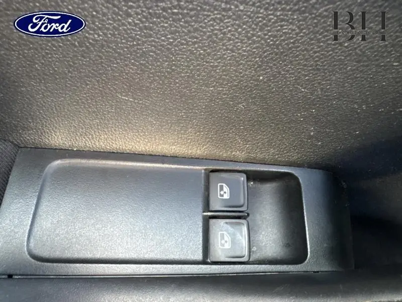 Gros plan sur les boutons de commande des vitres électriques côté conducteur d'une Skoda Fabia gris météore.