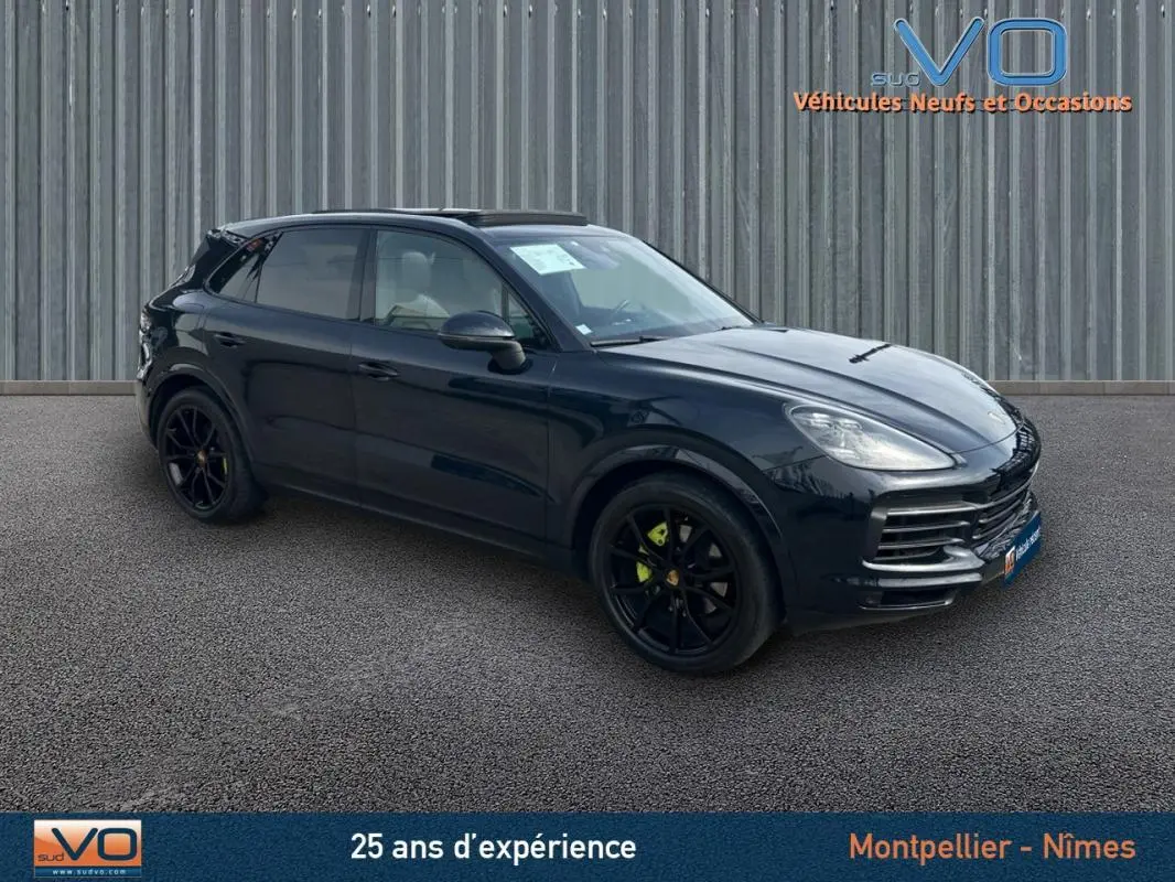 Vue 3/4 avant d'un Porsche Cayenne noir 2018 avec jantes noires et toit ouvrant panoramique visible.