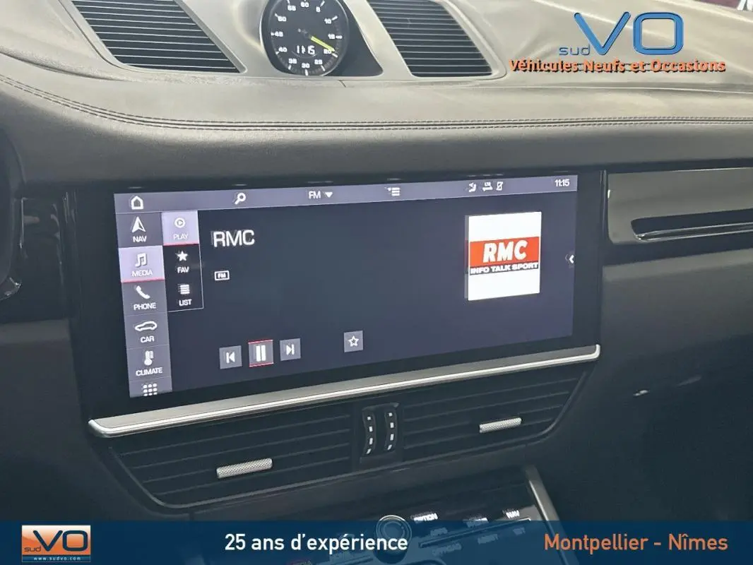 Vue rapprochée de l'écran multimédia noir du tableau de bord du Porsche Cayenne E-Hybrid 2018 affichant la radio RMC.