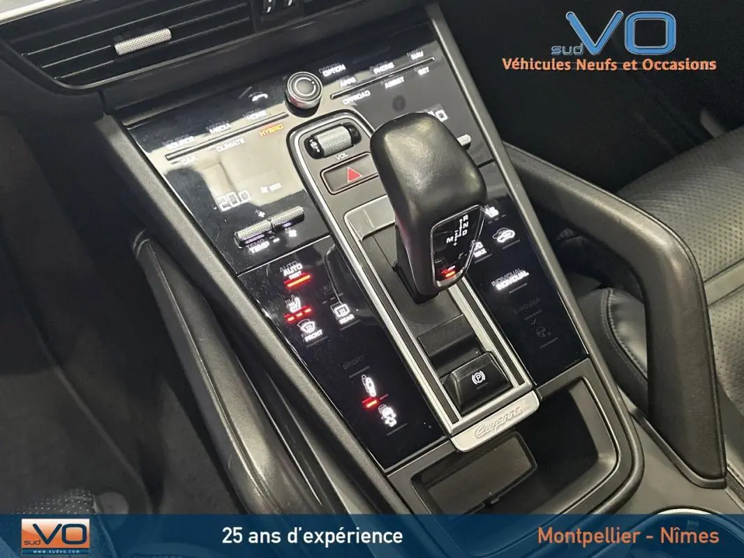 Gros plan sur la console centrale noire du Porsche Cayenne E-Hybrid 2018 avec levier de vitesse et commandes tactiles éclairées.