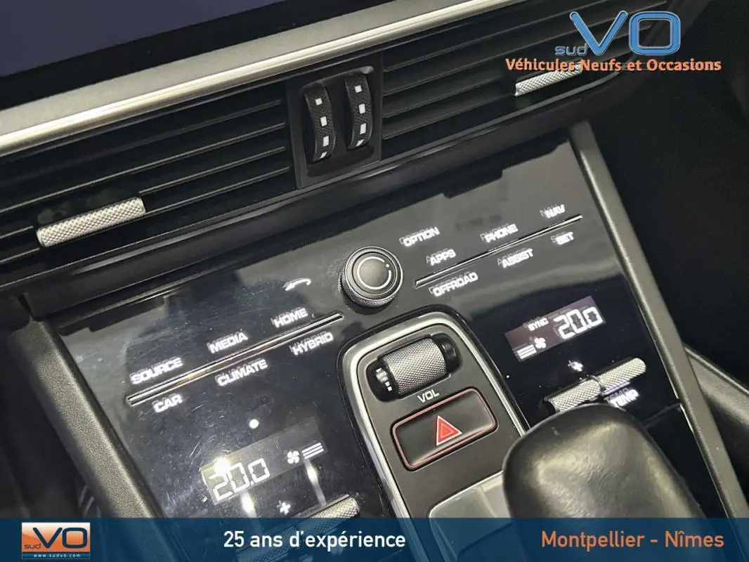 Vue rapprochée de la console centrale noire du Porsche Cayenne E-Hybrid 2018 avec commandes tactiles et molette de volume.