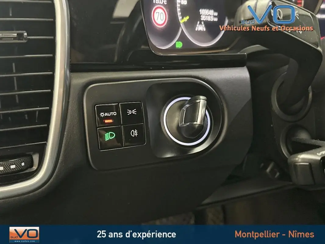 Gros plan sur les commandes d'éclairage et le bouton de démarrage du tableau de bord noir d'une Porsche Cayenne E-Hybrid 2018.