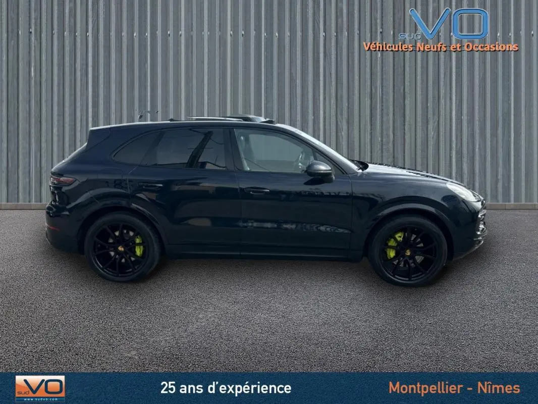 Profil latéral droit d'un Porsche Cayenne noir 2018 avec jantes noires et étriers de frein verts visibles.