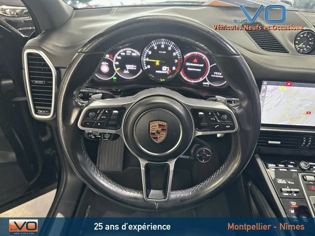 Vue rapprochée du volant sport noir et du tableau de bord numérique du Porsche Cayenne E-Hybrid 2018.